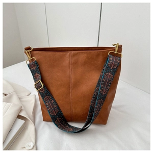 Détail du sac cabas caramel avec cuir texturé et bandoulière tissée à motif rétro