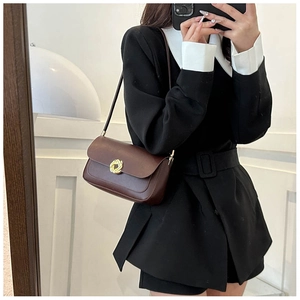 Détail d'un sac à bandoulière en cuir marron vintage avec boucle dorée en métal