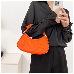 Detail of bright orange pleated crescent bag with quilted texture and cloud handle