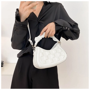 Detail of white woven texture handbag featuring a unique ruched handle and silver metal hardware