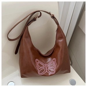 Detail view of pink butterfly embroidery on a brown PU leather hobo shoulder bag