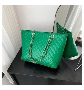 Dettaglio borsa shopper verde trapuntata con cuciture a rombi e tracolla catena oro