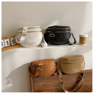 Détail de quatre sacs banane en cuir demi-lune avec bandoulières larges et zips dorés