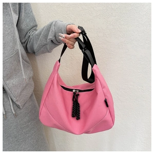 Détail du sac bandoulière rose en nylon imperméable avec sangle noire et fermeture éclair