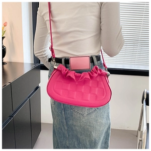 Detail of rose pink crossbody bag showing pleated edges and woven embossed leather texture