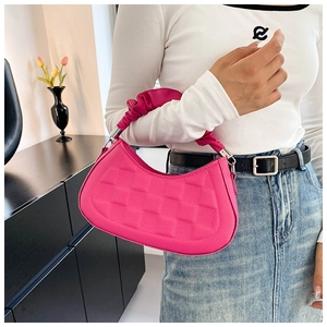 Close-up of hot pink hobo bag featuring quilted texture and ruched handle with silver hardware
