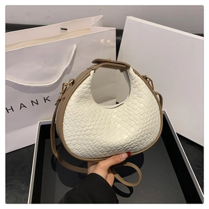 Dettaglio della borsa hobo a mezzaluna intrecciata bianco crema con finiture in pelle marrone