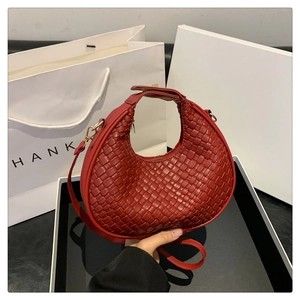 Dettaglio borsa hobo in pelle intrecciata rossa con cerniera d'oro e tracolla rimovibile