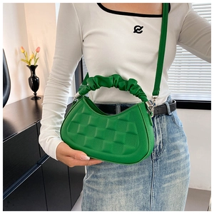 Detail of green PU leather shoulder bag with quilted pattern and ruched handle