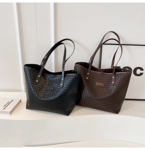 Detail of black and brown woven leather tote bags featuring fine crisscross texture