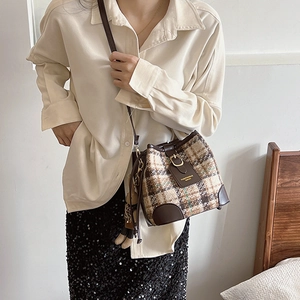 Retro plaid bucket bag with brown leather trim and cute bear charm shown on model