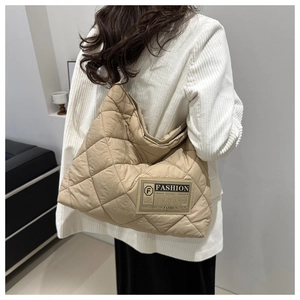 Gros plan détaillé du sac cabas beige matelassé avec surpiqûres en losanges et étiquette