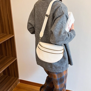 Sac bandoulière demi-lune blanc en cuir grainé avec fermetures éclair dorées et sangle