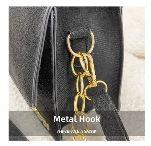 Nahaufnahme der goldenen Hardware-Haken und der dekorativen Metallkette der schwarzen Tasche