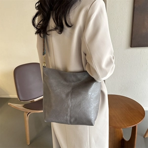 Sac seau gris chic avec bandoulière brodée ethnique dans un style intérieur rétro