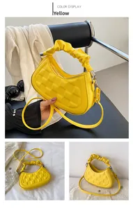 Detail of yellow crescent hobo bag with quilted texture and ruched handle