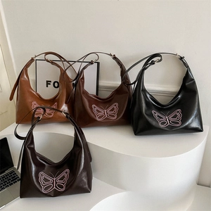 Modern butterfly embroidery tote bags in brown, caramel, and black PU leather on display