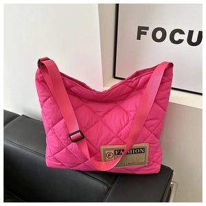 Détails du motif losange matelassé sur un sac fourre-tout en nylon de couleur magenta vif