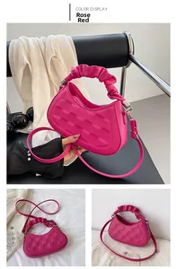 Detailed view of rose red pleated hobo bag with geometric texture and crossbody strap