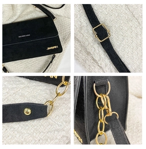 Details einer schwarzen Wildleder-Handtasche mit Goldkette und verstellbarem Riemen