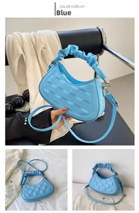Detail of blue pleated cloud bag showing lychee pattern faux leather and ruffled handle
