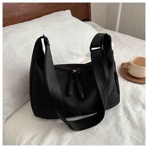 Détail du sac demi-lune en nylon noir avec doubles fermetures éclair et bandoulière large