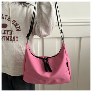 Détail du sac demi-lune rose avec sangle réglable et tirettes de fermeture tressées