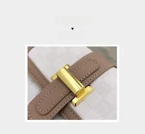 Détail du sac à motif à damier avec boucle en métal doré et lanière en cuir marron