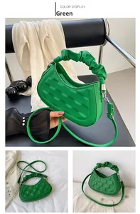 Close-up of green pleated handbag with woven texture and decorative scrunchie handle