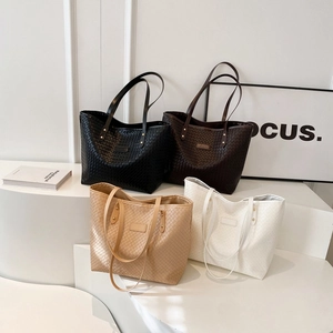 Minimalist large woven quilted tote bags in four classic colors for women displayed on stairs