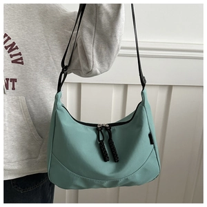 Détail du sac croissant en nylon vert menthe avec double fermeture éclair et tirettes