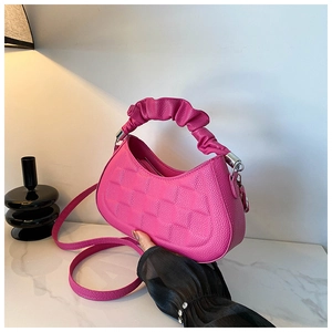 Detail of rose pink litchi grain leather texture and square quilted embossing on the handbag