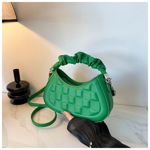 Macro detail of green lychee leather texture and square embossed pattern on a handbag