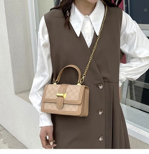 Sac bandoulière chic à damier avec chaîne dorée porté par un mannequin femme