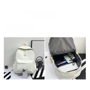 Detail view of large capacity white nylon backpack showing inner storage for tablet and gadgets