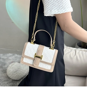 Détail du sac bandoulière en tissu tissé blanc avec garniture en cuir beige et doré