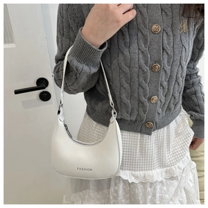 Close-up of a white crescent underarm bag with 'FASHION' text and metal zipper detail