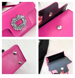 Detail view of magenta handbag featuring rhinestone buckle and protective metal base feet