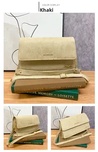 Detail einer khakifarbenen matten Veloursleder-Handtasche mit Metalllogo und Gurt