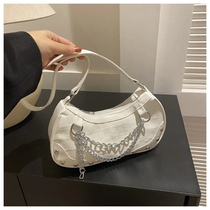 Detail of white moon bag featuring crocodile texture and silver chain accents