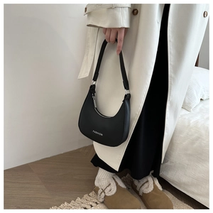 Model wearing a black minimalist leather half-moon shoulder bag with Fashion lettering