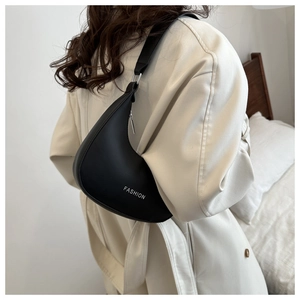 Detail of minimalist black matte leather hobo bag with white FASHION print on a model