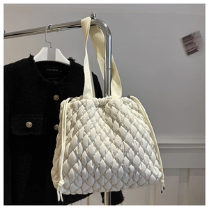 Close-up of quilted puffy tote bag with drawstring detail and elegant textured finish
