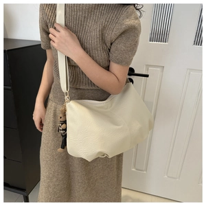 Detail of off-white large tote bag featuring golden hardware and a cute rabbit charm