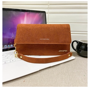 Nahaufnahme braune matte Wildleder Umhängetasche mit Goldkette und Aufdruck