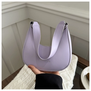 Close-up of lilac crescent shoulder bag featuring silver fashion text and smooth leather