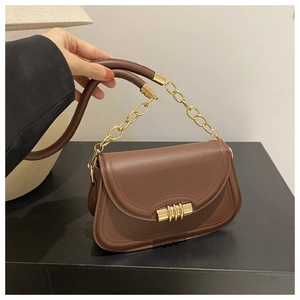 Gros plan du sac vintage en cuir marron avec bandoulière chaîne dorée et boucle ronde