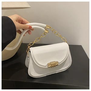 Gros plan du sac en cuir blanc avec poignée chaîne dorée et fermoir à trois anneaux chic