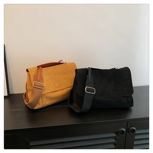 Detail view of retro faux suede crossbody bags in yellow and black with adjustable straps