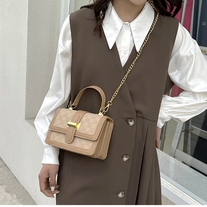 Petit sac carré marron à damier avec chaîne dorée et poignée, porté par un mannequin